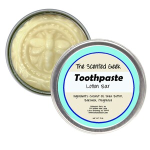 May include: A round, silver tin containing a light yellow lotion bar with a bee design. The tin is labeled "The Scented Geek Toothpaste Lotion Bar." Ingredients include coconut oil, shea butter, beeswax, and fragrance. Net weight is 2 oz.