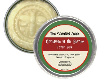 May include: A round, silver tin of lotion bar with the text "Christmas at the Burrow" and "The Scented Geek". The lotion is light yellow and has a bee design. The ingredients include coconut oil and shea butter.