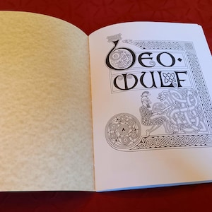 Puede incluir: Libro abierto con el t&iacute;tulo "Beo Wulf" en negro. La p&aacute;gina de la derecha presenta una ilustraci&oacute;n de un guerrero y un drag&oacute;n, con bordes y dise&ntilde;os de nudos celtas. La p&aacute;gina izquierda est&aacute; en blanco con textura de pergamino.