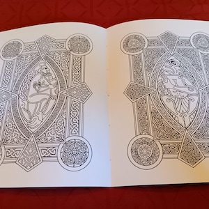 Puede incluir: Libro para colorear abierto en dos p&aacute;ginas, con intrincados dise&ntilde;os de nudos celtas. Cada p&aacute;gina presenta una figura ovalada central rodeada de patrones geom&eacute;tricos y elementos circulares. Las p&aacute;ginas est&aacute;n sobre una superficie roja.