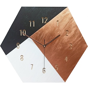 May include: A hexagonal clock with black, white, and copper colored sections. The clock face has gold numbers and black hands.