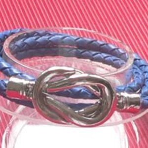 Könnte beinhalten: Ein blaues Lederarmband mit einem silbernen Knotenschließe.