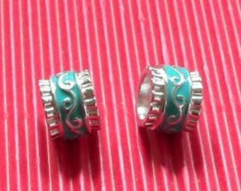 May include: Two turquoise blue and silver metal spacer beads with a decorative swirl design.