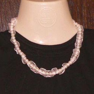 May include: A white pearl and clear plastic bead necklace. The necklace is made of small white pearls and clear plastic beads that are shaped like leaves. The necklace is about 18 inches long.