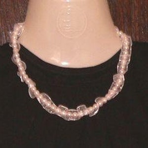 May include: A delicate necklace with alternating white pearls and clear, faceted glass beads. The necklace is approximately 18 inches long.