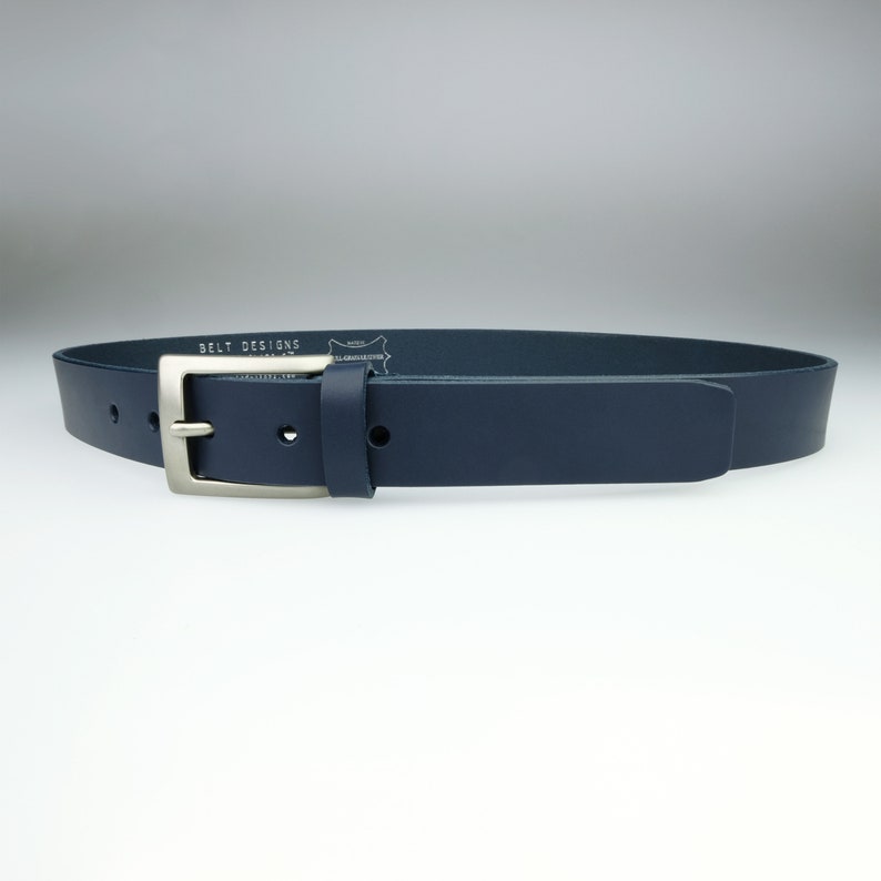 May include: A dark blue leather belt with a silver buckle. The belt has the text "BELT DESIGNS" embossed on the back.