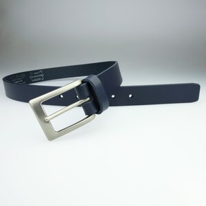 May include: A dark blue leather belt with a silver buckle. The belt is made of high-quality leather and has a classic design.