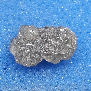 Peut inclure: Un cristal de diamant brut, gris et noir, avec une finition naturelle non polie.