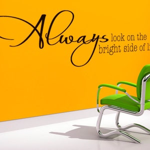 Peut inclure: Une chaise verte avec un cadre chromé sur un mur jaune avec le texte "Always look on the bright side of life!" en noir.
