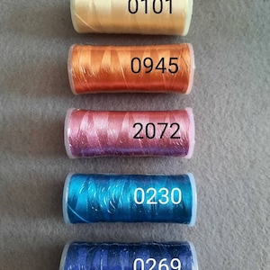 May include: Five spools of embroidery floss in different colours. The spools are labelled with the numbers 0101, 0945, 2072, 0230, and 0269.