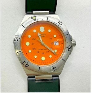 May include: A stainless steel Swiss Army watch with an orange face and luminous markers. The watch features a date display and a black and green band. The bezel has numbers and markers for timekeeping.