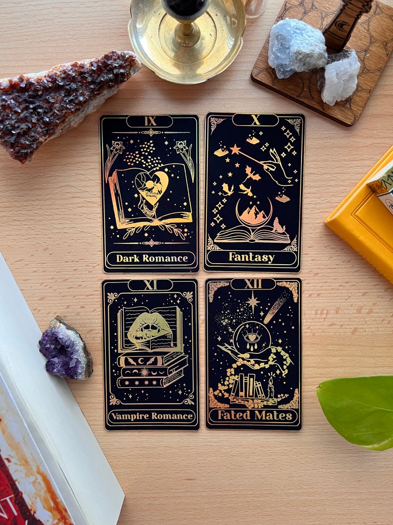 May include: Four tarot cards with gold foil accents on a black background. The cards are numbered IX, X, XI, and XII. The card titles are "Dark Romance", "Fantasy", "Vampire Romance", and "Fated Mates".