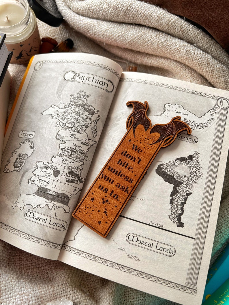 May include: Wooden bookmark featuring a dragon with wings outstretched and the text "We don't bite, unless you ask us to."