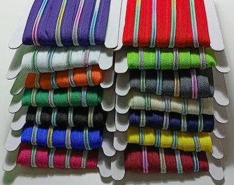 May include: Assortment of zipper tapes in various colors, including purple, red, green, white, orange, black, blue, yellow, and pink. Each tape has a white and silver stripe running down the center.