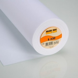 Könnte beinhalten: Eine weiße Rolle Vlieseline-Einlage mit der Bezeichnung "Vlieseline Vilene S 320", einem Barcode und dem Text "90 cm x 25 m 100% PES".