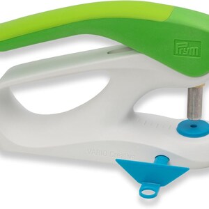 Peut inclure: Un outil de poinçonnage manuel blanc et vert avec un guide bleu. L'outil est marqué "VARIO Creative" et "Prym".