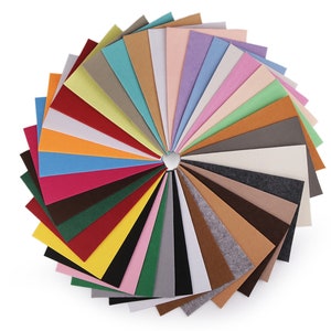 Op de afbeelding: Een selectie van viltvierkanten in verschillende kleuren, gerangschikt in een cirkel. De kleuren omvatten rood, oranje, geel, groen, blauw, paars, bruin, zwart, wit en grijs.