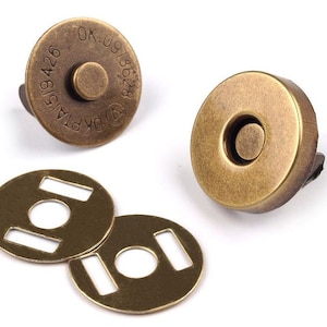 May include: Two antique gold magnetic snap closures with two matching metal plates. The snap closure has a round, flat top with a recessed center. The plates are round with a rectangular opening.