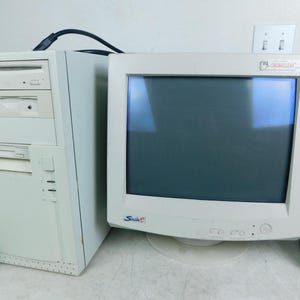 May include: A beige desktop computer tower with a CD-ROM drive and floppy disk drive, paired with a matching beige CRT monitor featuring a Smile logo on the front bezel and a small sticker at the top right corner labeled ClearView.