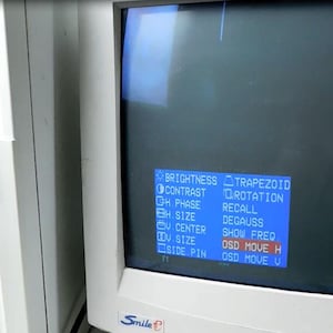 May include: A beige computer tower sits next to a beige CRT monitor displaying a blue on-screen display menu with settings like brightness, contrast, and trapezoid. The monitor features an Energy Star logo in the top right corner and a Smile logo.