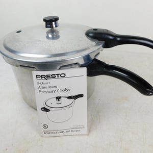 May include: An 8-quart aluminum pressure cooker by Presto. The cooker has a silver body, a black handle, and a black knob on the lid. A white instruction manual is in front of the cooker.