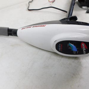 May include: A white and black Minn Kota Endura trolling motor. The motor has a gray handle and a black shaft. The motor has a gauge with blue and green indicators and the brand name "endura" in red.