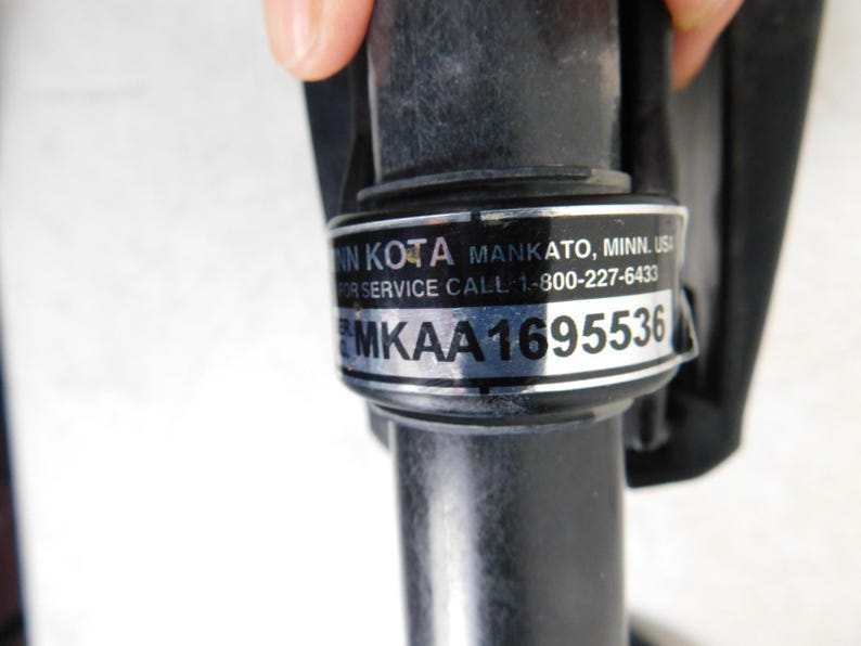 May include: Close-up of a black cylindrical component with a silver label. The label includes the text "MIN KOTA MANKATO, MINN, USA" and a service call number. The serial number "MKA1695536" is also visible.