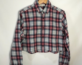 Puede incluir: Una camisa de manga larga a cuadros rojos, blancos y azules, con cierre de botones en la parte delantera y un solo bolsillo en el lado izquierdo. La camisa tiene una etiqueta "Urban Thread".