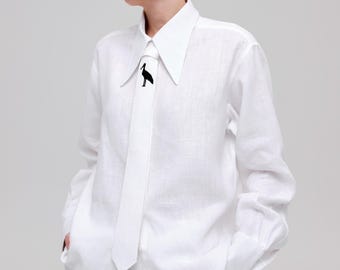 May include: A crisp white long-sleeved button-down shirt with a pointed collar and a matching white necktie. The tie features a small, black, minimalist graphic of a standing stork centered on the upper portion of the fabric.