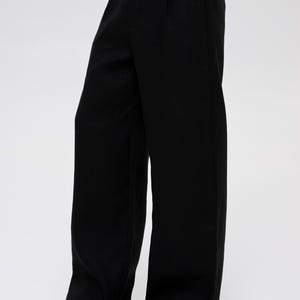 May include: Black wide-leg pants with a pleated front and a straight leg.