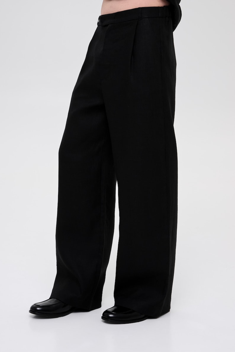 May include: Black wide-leg pants with a pleated front and a straight leg.