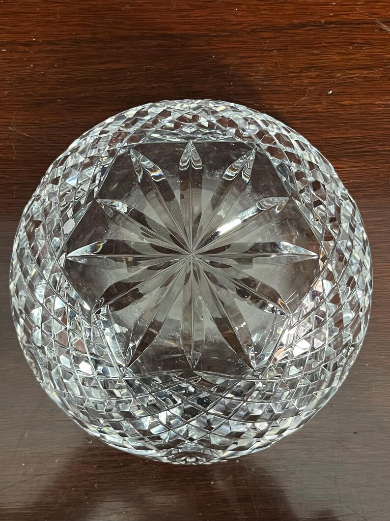 Puede incluir: Un cuenco de vidrio transparente con un dise&ntilde;o de cristal tallado. El cuenco tiene un patr&oacute;n de estrella en el centro y un patr&oacute;n de diamante alrededor de los bordes.