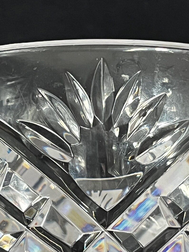 Puede incluir: Primer plano de un cuenco de vidrio transparente con un dise&ntilde;o de cristal tallado. El cuenco tiene un patr&oacute;n de estrella en la parte inferior.