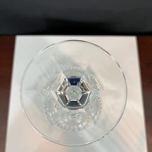 May include: A clear glass goblet with a cut crystal design. The goblet has a wide bowl and a tall stem.