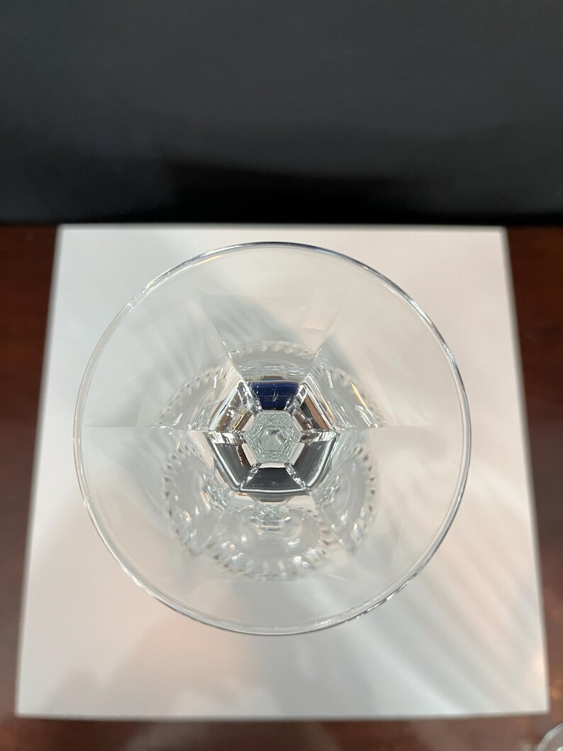 May include: A clear glass goblet with a cut crystal design. The goblet has a wide bowl and a tall stem.