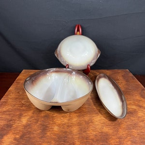 May include: A set of three ceramic serving dishes in a brown and white glaze. The set includes a divided serving bowl, a small oval dish, and a round bowl.