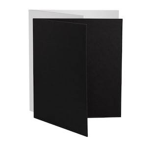May include: A tri-fold card with a black interior and a white exterior.