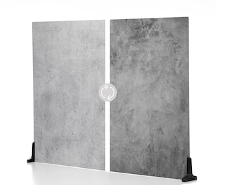 May include: Two gray concrete panels with a white dividing line and a circular arrow symbol. The panels are supported by black stands. The left panel has a lighter, more speckled texture, while the right panel is darker with visible markings.