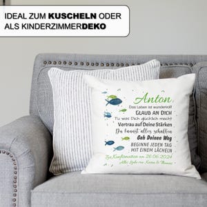 May include: A white square throw pillow featuring a watercolour illustration of small blue and green fish. The text reads: Anton, Das Leben ist wundervoll!, GLAUB AN DICH, Tu was Dich gl&uuml;cklich macht, Vertrau auf Deine St&auml;rken, Du kannst alles schaffen, Geh Deinen Weg, BEGINNE JEDEN TAG MIT EINEM L&Auml;CHELN, Zur Konfirmation am 26.06.2024, Alles Liebe von Karin & Thomas.