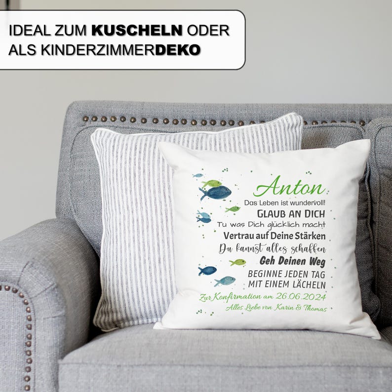 May include: A white square throw pillow featuring a watercolour illustration of small blue and green fish. The text reads: Anton, Das Leben ist wundervoll!, GLAUB AN DICH, Tu was Dich gl&uuml;cklich macht, Vertrau auf Deine St&auml;rken, Du kannst alles schaffen, Geh Deinen Weg, BEGINNE JEDEN TAG MIT EINEM L&Auml;CHELN, Zur Konfirmation am 26.06.2024, Alles Liebe von Karin & Thomas.
