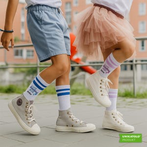 May include: Two children wearing high-top sneakers and knee-high socks. One child wears blue shorts and the other a pink tutu. The socks have text and stripes. The sneakers are gray and white.