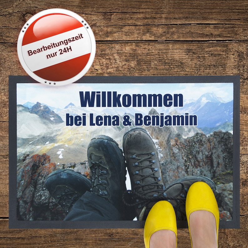 May include: A welcome mat with a mountain scene and the text "Willkommen bei Lena & Benjamin". Two pairs of shoes are on the mat, one pair of yellow sandals and one pair of brown hiking boots.