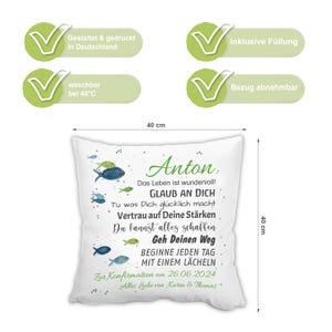 May include: A square white throw cushion measuring 40 cm by 40 cm, featuring a watercolour fish design and German text including the name Anton, inspirational phrases, and the date 26.06.2024. The cushion includes a removable cover and filling.