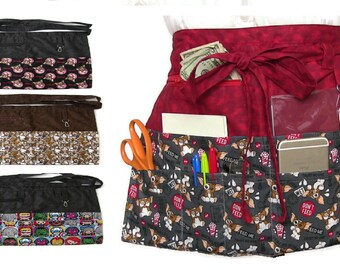 Peut inclure: Trois tabliers de taille différents avec des motifs colorés variés. Les tabliers ont plusieurs poches et une fermeture à nouer. Les motifs comprennent un chien noir et blanc, un personnage de dessin animé et un chien brun et blanc.