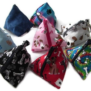 Puede incluir: Ocho pequeñas bolsas triangulares con cremallera con varios estampados con temática de perros. Las bolsas están hechas de tela y tienen un cierre de cremallera. Los estampados incluyen huellas de patas, huesos y perros.