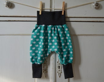 Op de afbeelding: Turquoise baby broek met een witte walvisprint en een zwarte tailleband.