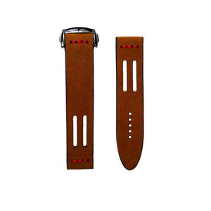 May include: A brown leather watch strap with red stitching and a silver buckle.