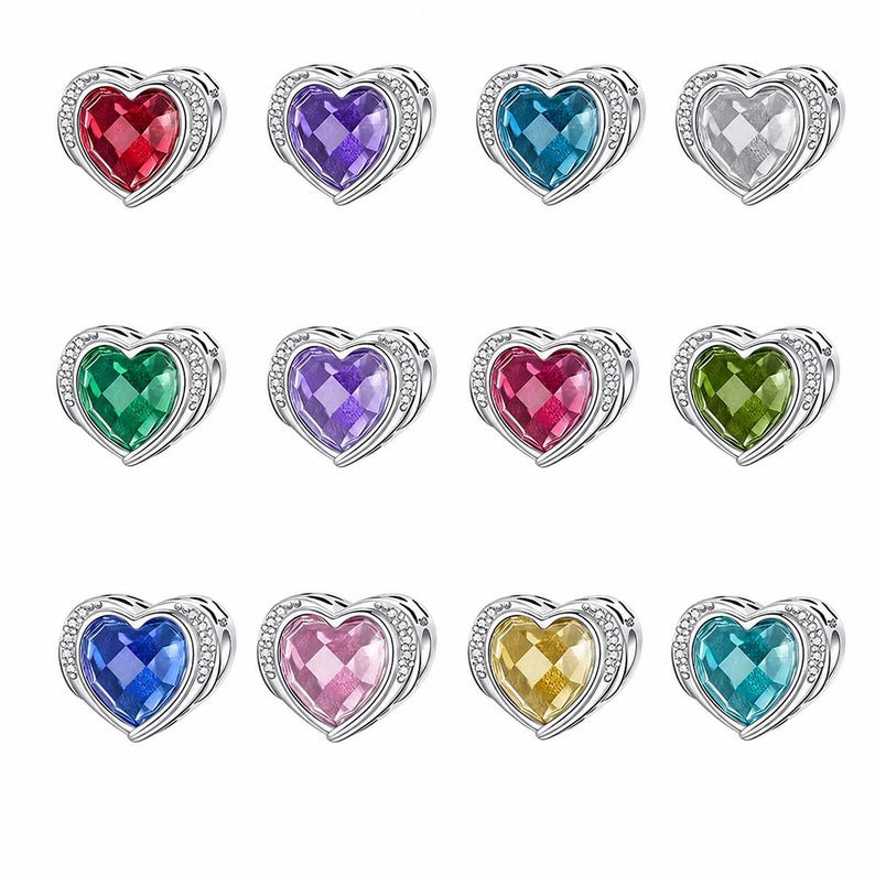 May include: A collection of heart-shaped charms in various colors, including red, purple, blue, and green. Each charm features a faceted gemstone center and is surrounded by a silver-colored frame with small, clear accent stones. The charms are designed for jewelry.