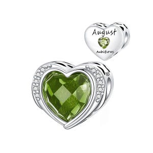 May include: A heart-shaped charm with a large, faceted green gemstone center, surrounded by a silver frame and small clear stones. The charm is labeled "August" and "Ambitious" with a smaller green stone.