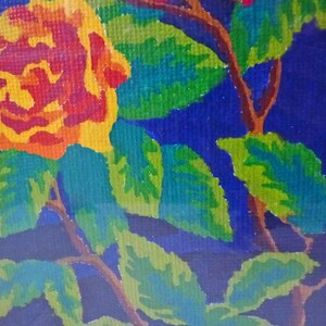 May include: A close-up of a painting depicting a single yellow rose with red accents, surrounded by green leaves on a dark blue background.